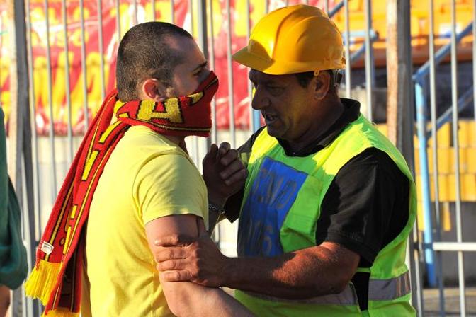 Uno steward dello stadio Via del Mare prova a fermare un tifoso a volto coperto. Evangelista